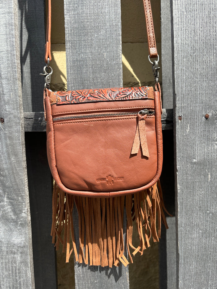 Brown leather crossbody bag with a fringe sides and a tooled design on the flap. Rear View