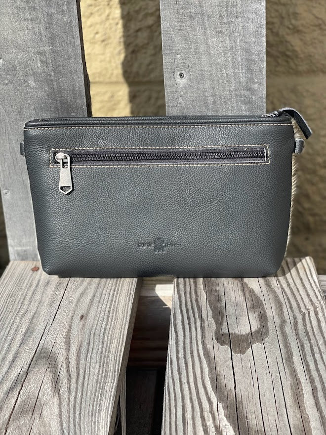 Black leather and cowhide wristlet bag that also comes with a removable adjustable crossbody strap. This is a larger wristlet with a inside zip close pocket and credit card slots.  Rear view showing sold black leather and outside zippered closed pocket.