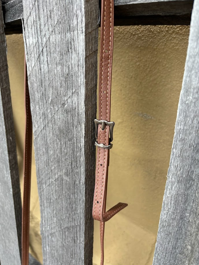 Cowhide and Coffee Brown tooled leather bag with side fringe. This bag features removable wristlet and shoulder straps. Close up view of adjustable shoulder strap.