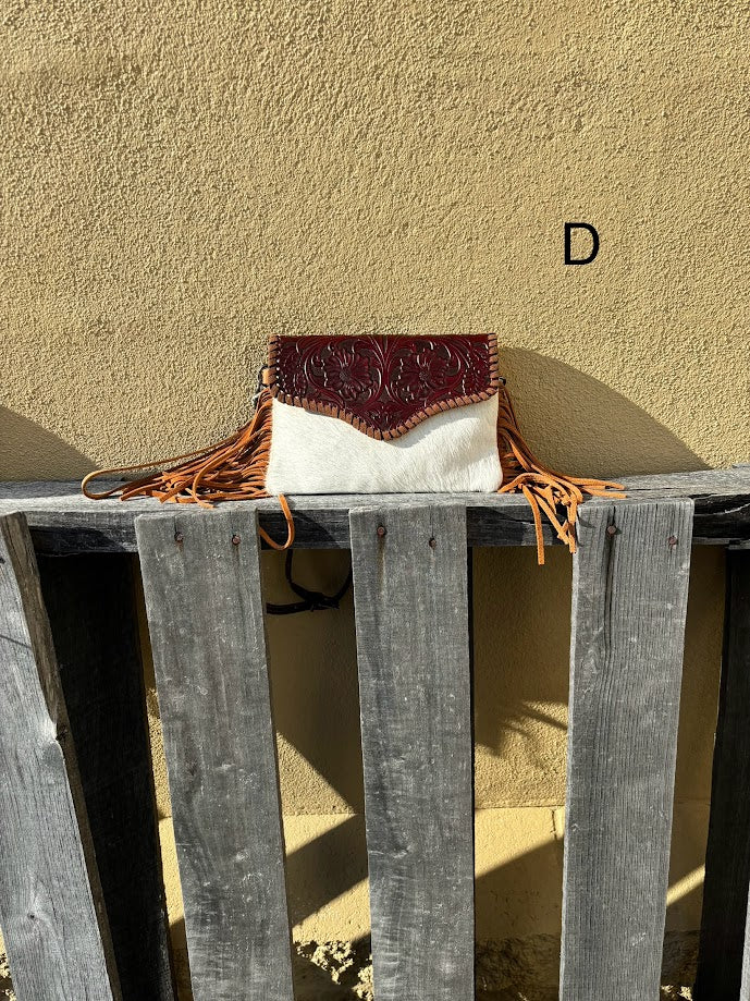 Brown tooled leather and cowhide bag with side fringe. This bag has both a wristlet and should strap. Front View  D