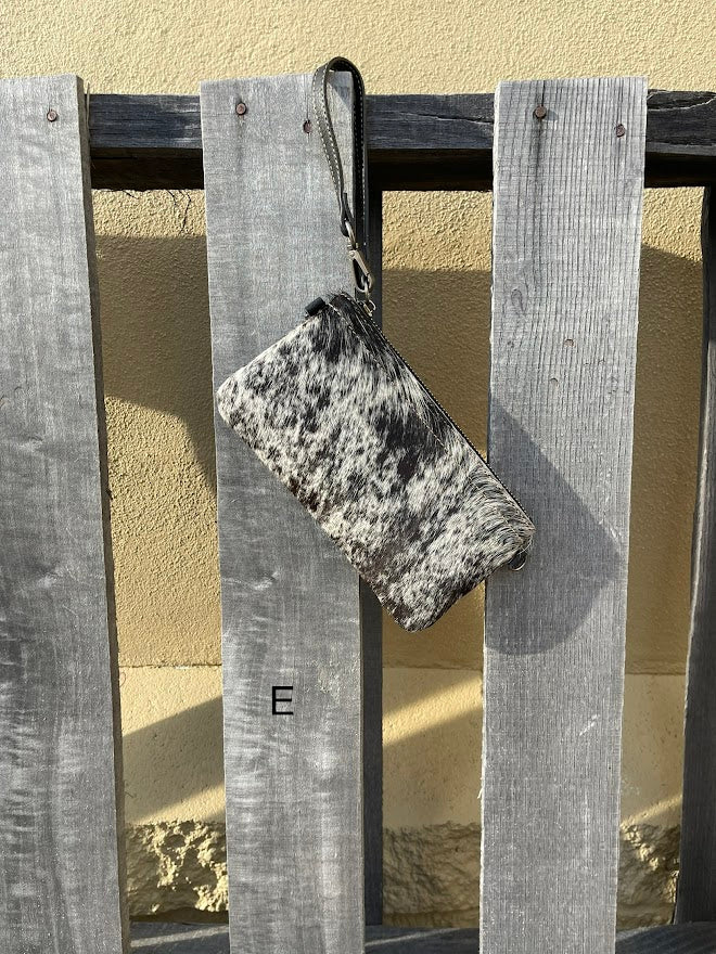 Cowhide wristlet purse in Black leather with a zippered closure. This bag has a wristlet handle or shoulder strap. Front View E