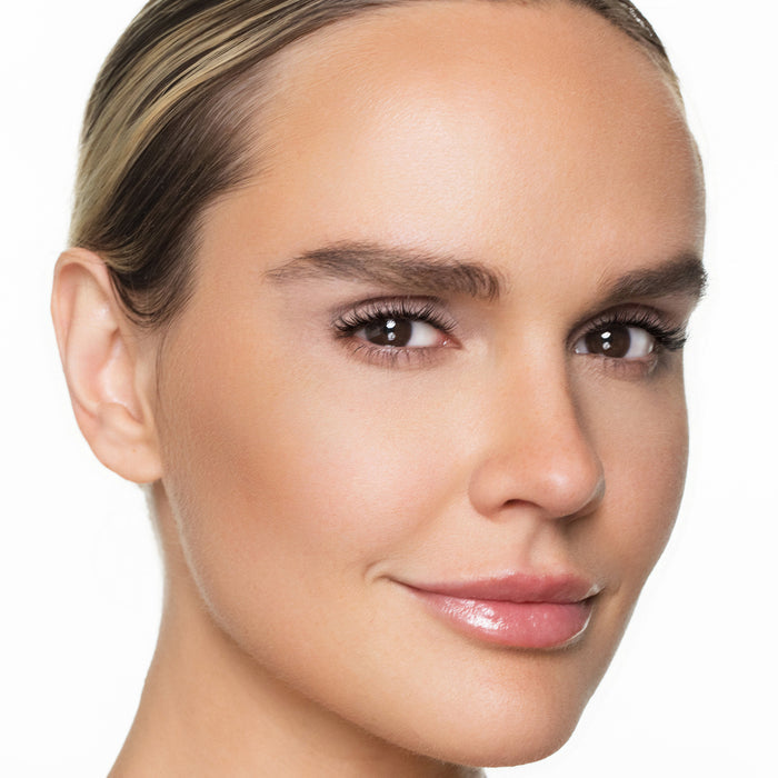 Close-up of a woman's face with cream bronzer  on a white background