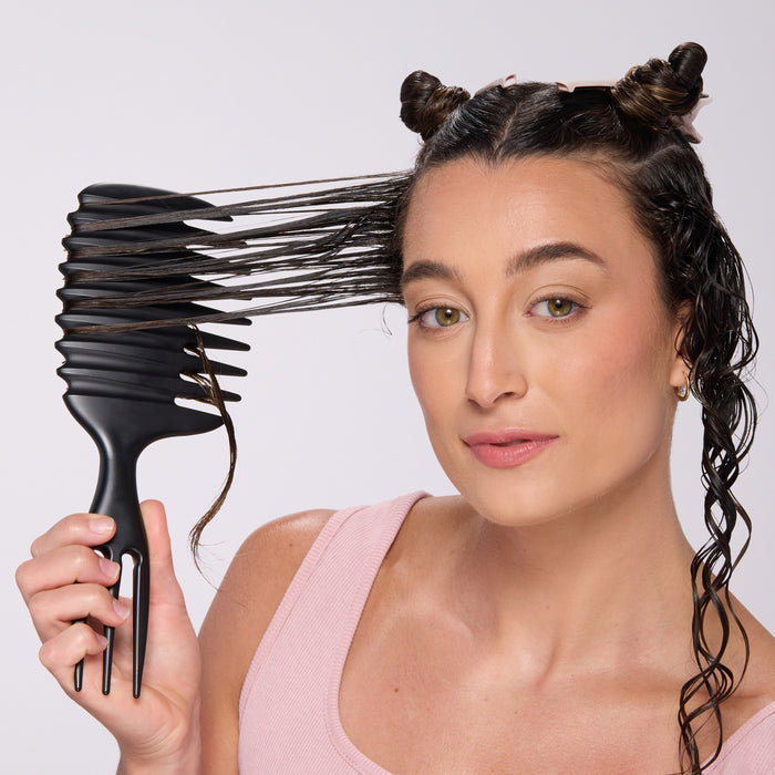 Model pulling hair through the TriWave brush to define curls