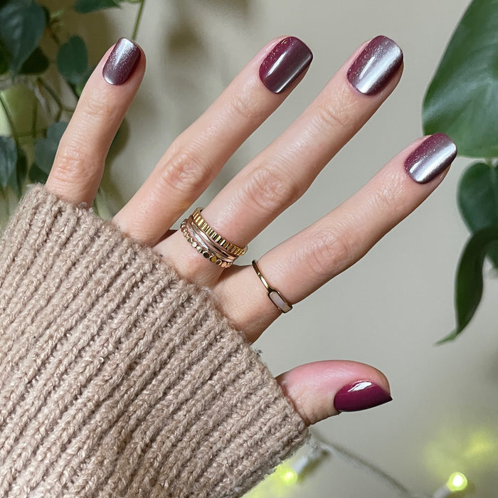 Hand showing Velvet Berry - Press-On | Extra Short | Squoval false nails with shimmery velvet berry finish and cozy sweater background