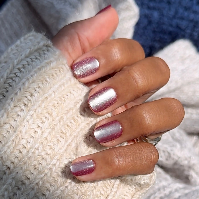 Hand wearing Velvet Berry - Press-On | Extra Short | Squoval false nails with shimmery velvet berry finish and cozy knit sweater background