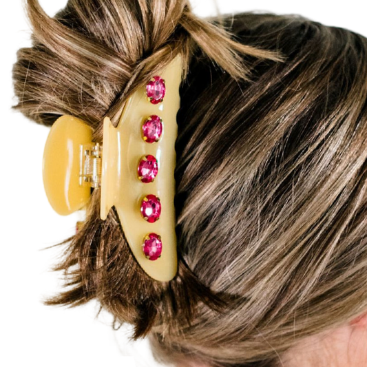 Hair clip with pink gemstones in a person's hair on a white background