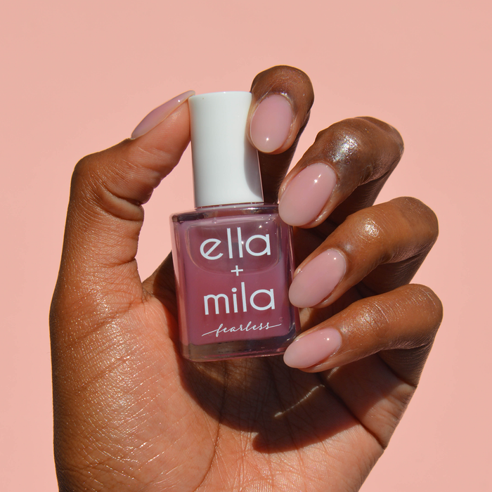 You Glow Girl milky purple pink nail polish on a deep skin tone, hand holding the bottle
