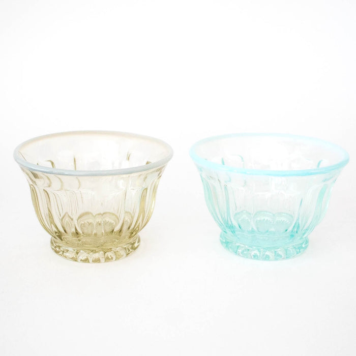 Two Yuki No Hana glass tea cups, one with a light blue tint and the other with a yellowish tint, both with a milky gradient at the rim, displayed against a white background.